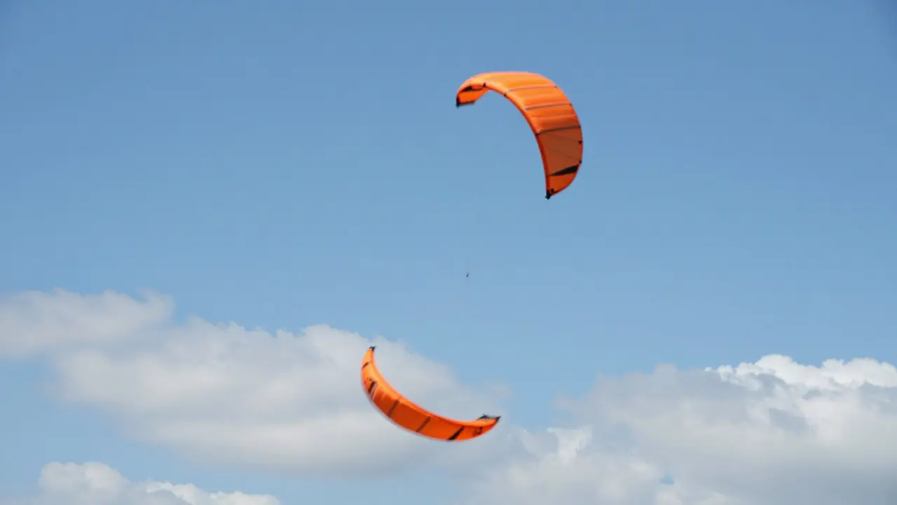 Stunt kite spinning in a spiral cascade against a blue sky