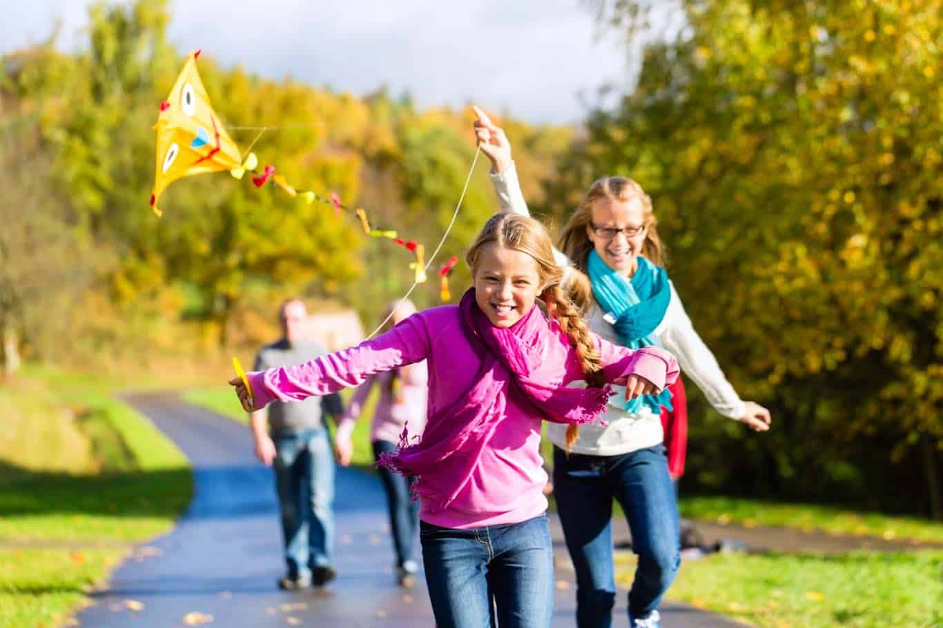 Kids flying kites with trees in background changing colors
