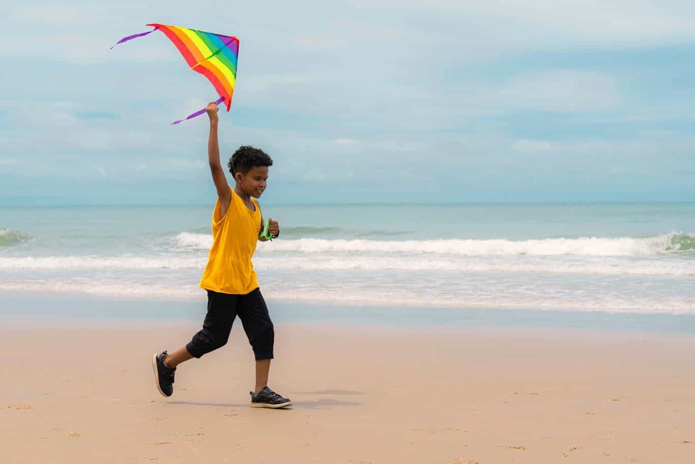 Boy on beach with kite.