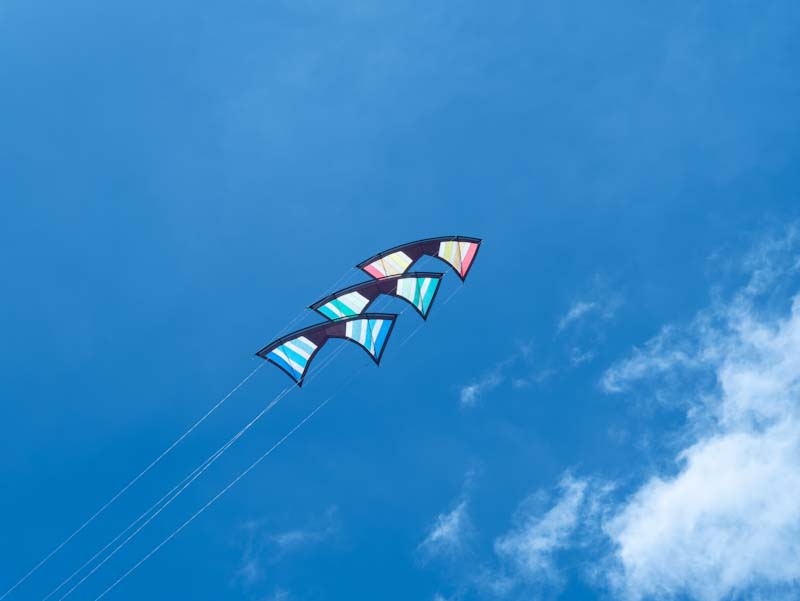3 kites stacked on top of each other in blue sky